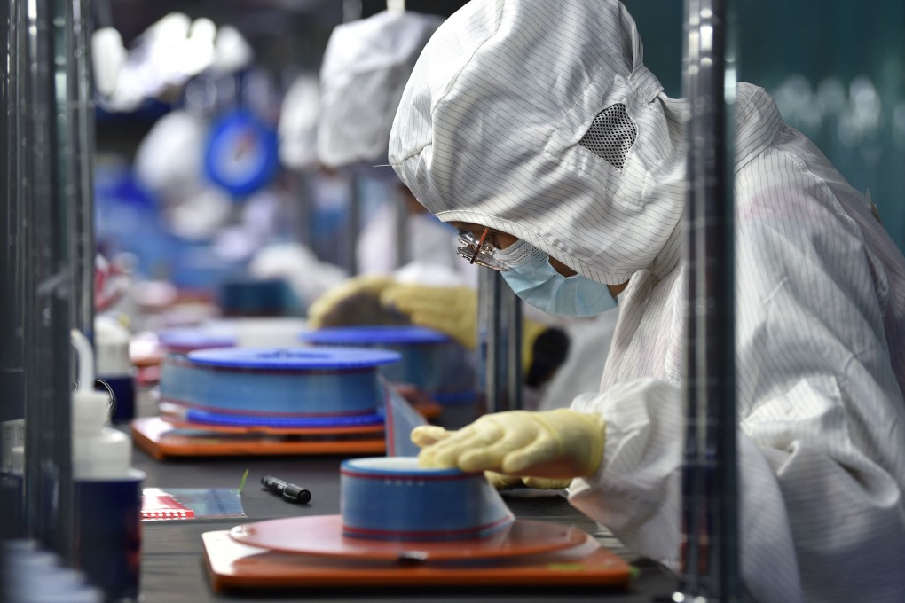 Workers produce adhesive tapes for flexible printed circuits at a factory in Yancheng in China's eastern Jiangsu province on September 15, 2021. Photo: AFP