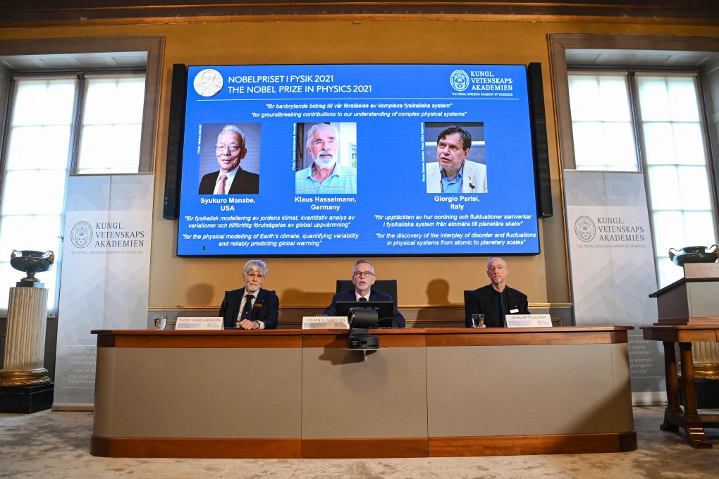 Goran K. Hansson, centre, secretary general of the Royal Swedish Academy of Sciences, and members of the Nobel Committee for Physics sit in front of a screen displaying the co-winners of the 2021 Nobel Prize in Physics (from left) Syukuro Manabe, Klaus Hasselmann and Giorgio Paris. Photo: AFP