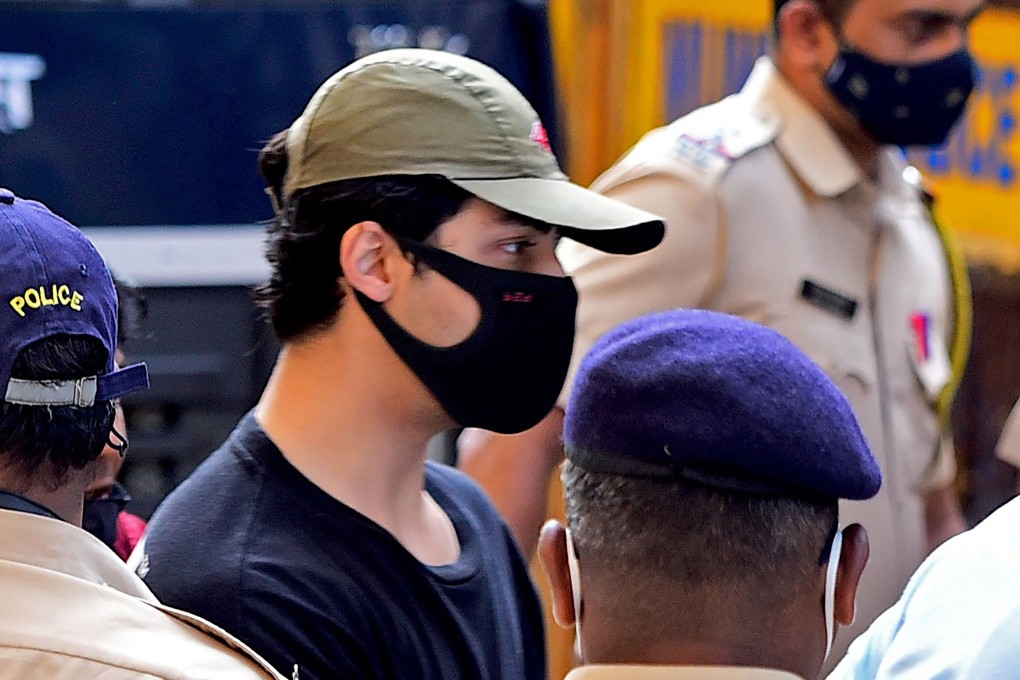Bollywood actor Shah Rukh Khan's son Aryan Khan is escorted by officials outside the Narcotics Control Bureau office after he was arrested along with others following a raid on a party on a cruise ship. Photo: AFP