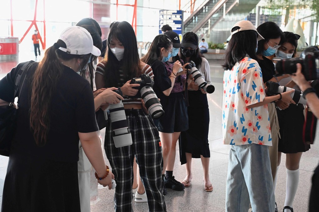 Fans holding cameras wait for celebrities at Beijing’s Capital Airport, but state regulations have banned some aspects of fandom as part of a crackdown. Photo: AFP