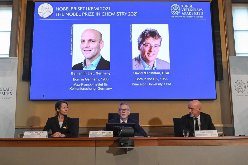 A screen displays the winners of the 2021 Nobel Prize in Chemistry scientists Benjamin List (left) and David MacMillan. Photo: AFP