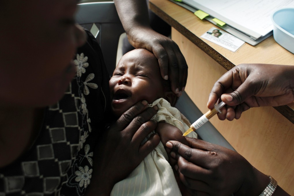 A mother holds her baby, who is receiving a new malaria vaccine as part of a trial at the Walter Reed Project Research Centre in Western Kenya in October 2009. Photo: AP