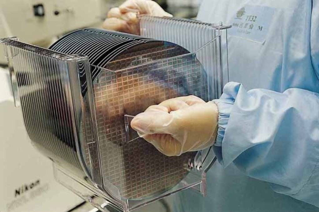 A Taiwan Semiconductor Manufacturing Co carries semiconductor wafers. TSMC has been forced to cut off sales to some Chinese companies as a result of US sanctions. Photo: TSMC