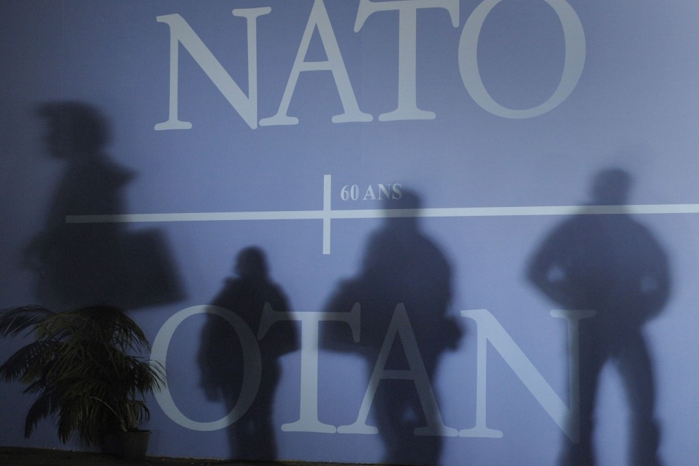 Attendees’ shadows are cast on a wall decorated with the Nato logo before the start of a summit in France in April 2009. Photo: AFP