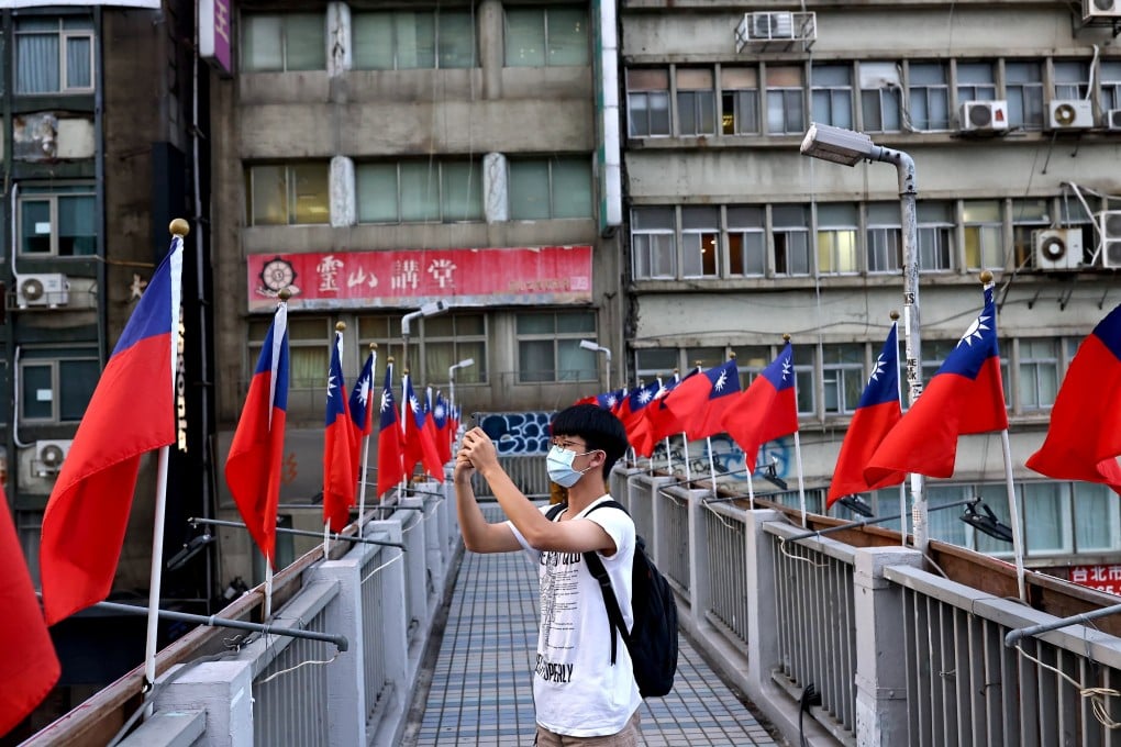 A man photographs Taiwanese flags put up in Taipei ahead of the October 10 celebrations, but the island’s government is less keen on the flag. Photo: Reuters