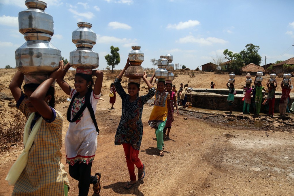 Villagers on the outskirts of Mumbai collect water from an almost-dry well in 2016. Photo: EPA