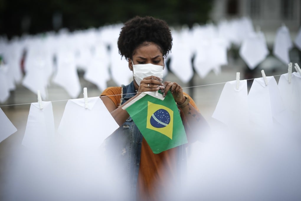 A volunteer helps to hang white handkerchiefs during a tribute to the thousands of victims of Covid-19 in Brazil in Rio de Janeiro on Friday. Photo: EPA-EFE