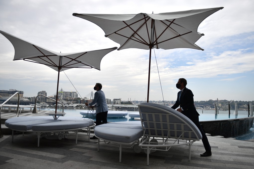 Workers begin reopening preparation by setting up pool umbrellas at Crown Sydney on Sunday. Photo: AAP Image/dpa