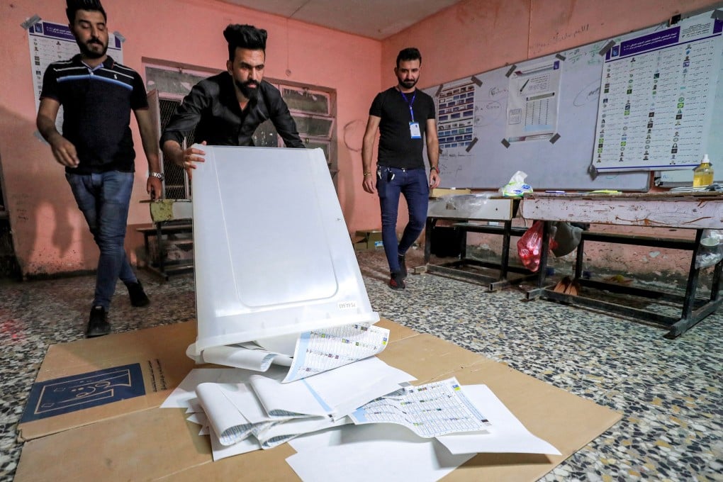 Iraqi election officials conduct a manual count of votes at a polling station in the capital Baghdad on Sunday. Photo: AFP