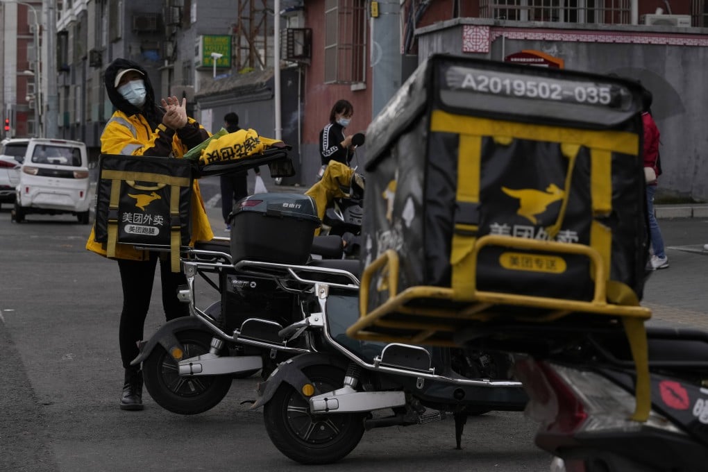 A delivery person for Meituan, operator of China’s largest on-demand local services and food delivery platform, prepares for work in Beijing. Photo: AP