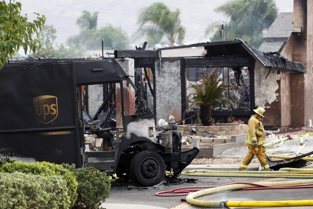 A firefighter walks by the debris of the crash that killed a UPS driver. Photo: TNS