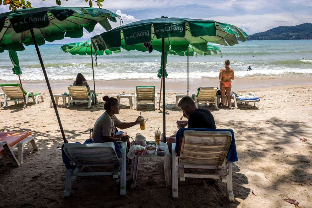 People under the shade of a beach umbrella in Phuket, Thailand. Photo: AFP