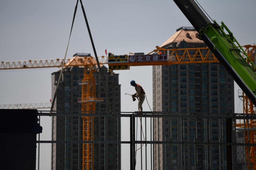 A worker prepares to weld a steel structure at a construction site in Beijing. Chinese property firms are scrambling to avoid outright default on their upcoming debt obligations. Photo: AFP