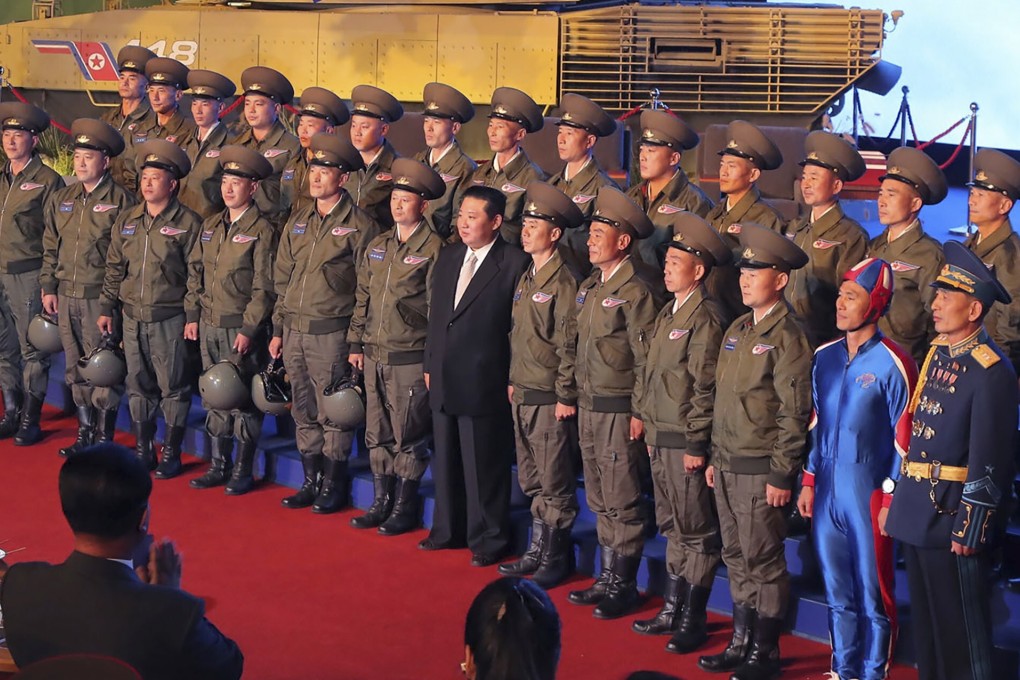 North Korean leader Kim Jong-un, centre, poses for a group photo with soldiers and fighter pilots who made the demonstration flight at the opening of an exhibition of weapons systems in Pyongyang. Photo: AP