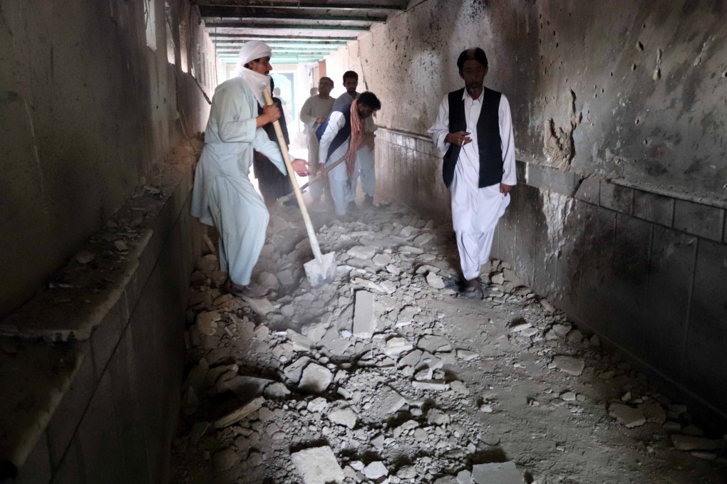 Debris is cleared at the scene of bomb blasts at a Kandahar mosque on Friday. Photo: EPA-EFE