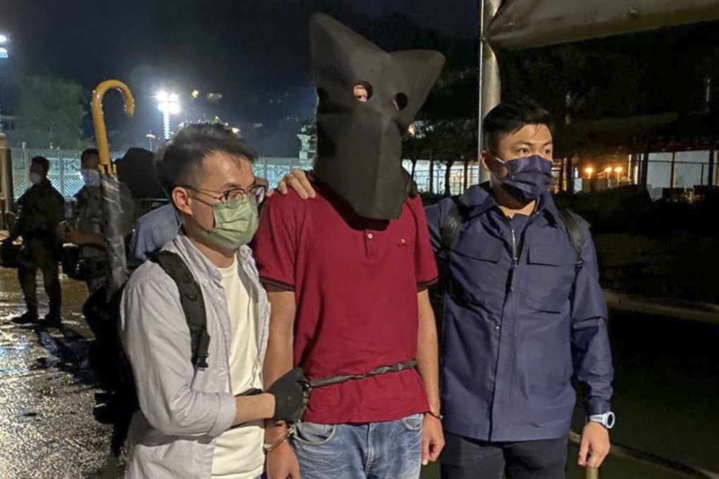 Police escort the suspect in the murder of a taxi driver following his arrest on Lamma Island. Photo: Handout