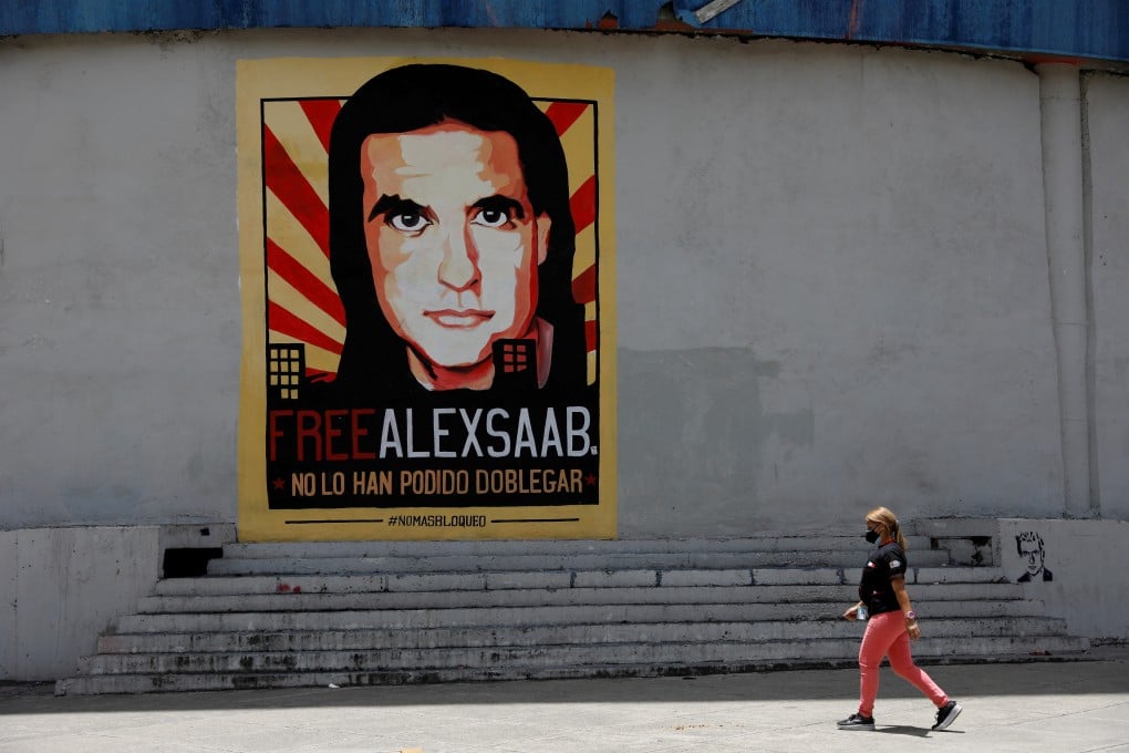 A woman walks by a mural in support of the liberation of businessman Alex Saab in Caracas, Venezuela. Photo: Reuters