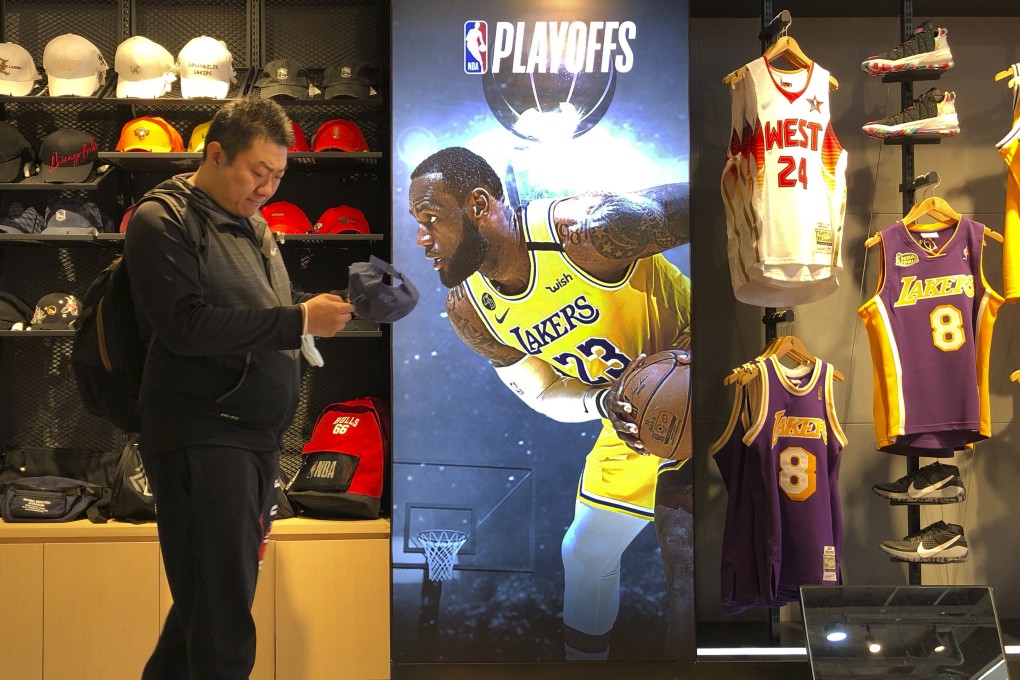 A man shops for merchandise near a billboard of Los Angeles Lakers star LeBron James promoting the NBA playoffs at an NBA store in Beijing in October 2020. The NBA is returning to Chinese state television after a one-year absence. Photo: AFP