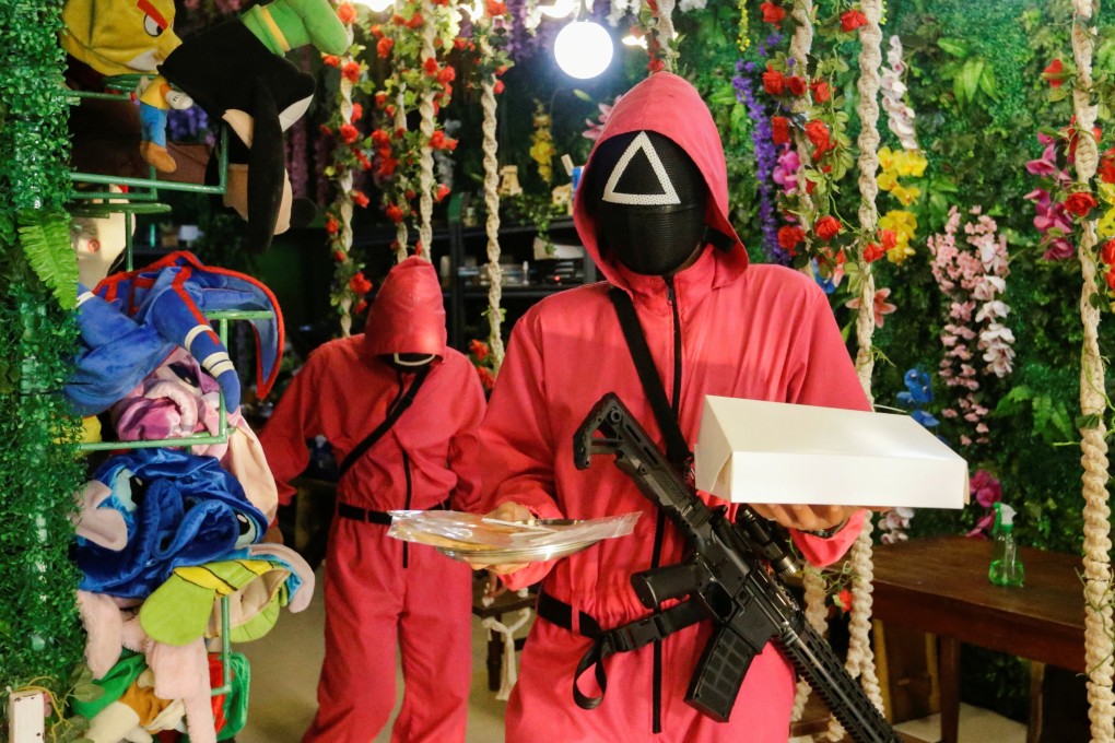Waiters wearing ‘Squid Game’ costumes carry trays with dalgona honeycomb toffee at Strawberry Cafe in Jakarta, Indonesia. Photo: Reuters