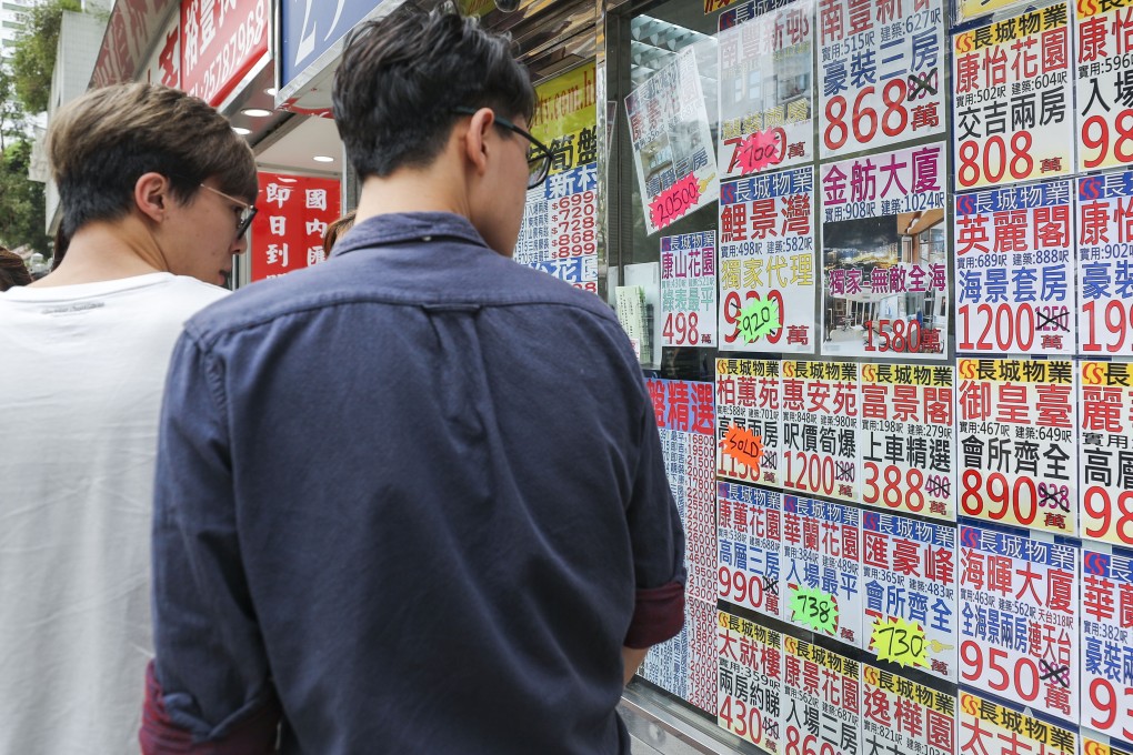 Residential property ads are displayed on the window of a property agency in Quarry Bay. Photo: Edward Wong
