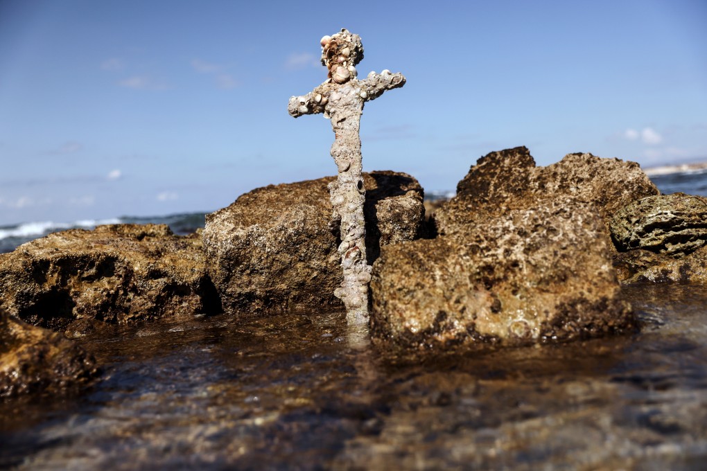 A sword believed to have belonged to a crusader who sailed to the Holy Land almost a millennium ago stands in the water on Monday near to where it was recovered from the Mediterranean seabed by an amateur diver in Caesarea, Israel. Photo: Reuters