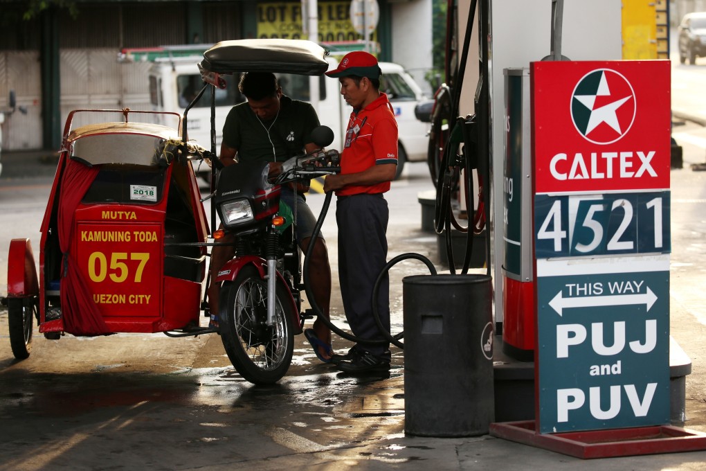 A tricycle driver gets his vehicle filled at a Caltex petrol station in Quezon City, Metro Manila. The Philippines is facing above-target inflation and calls to hike rates. Photo: Reuters