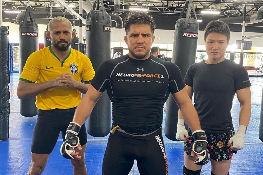 Henry Cejudo (centre) poses with Zhang Weili (right) and Deiveson Figueiredo at the Fight Ready gym in Scottsdale, Arizona.