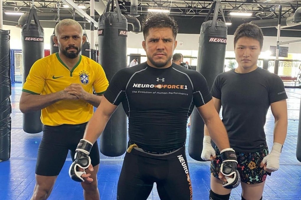 Henry Cejudo (centre) poses with Zhang Weili (right) and Deiveson Figueiredo at the Fight Ready gym in Scottsdale, Arizona.