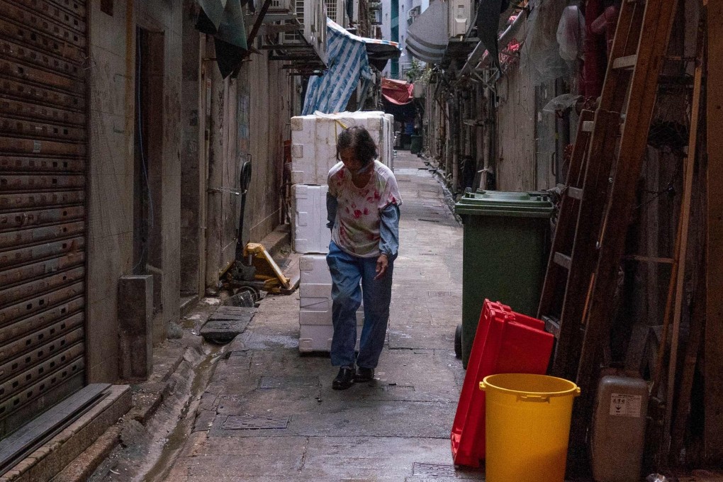 A woman pulls styrofoam boxes at a back alley in Hong Kong. Photo: AFP