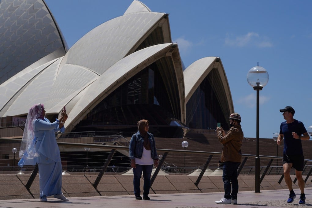 People take pictures in front of the Opera House in Sydney, Australia. Photo: Reuters