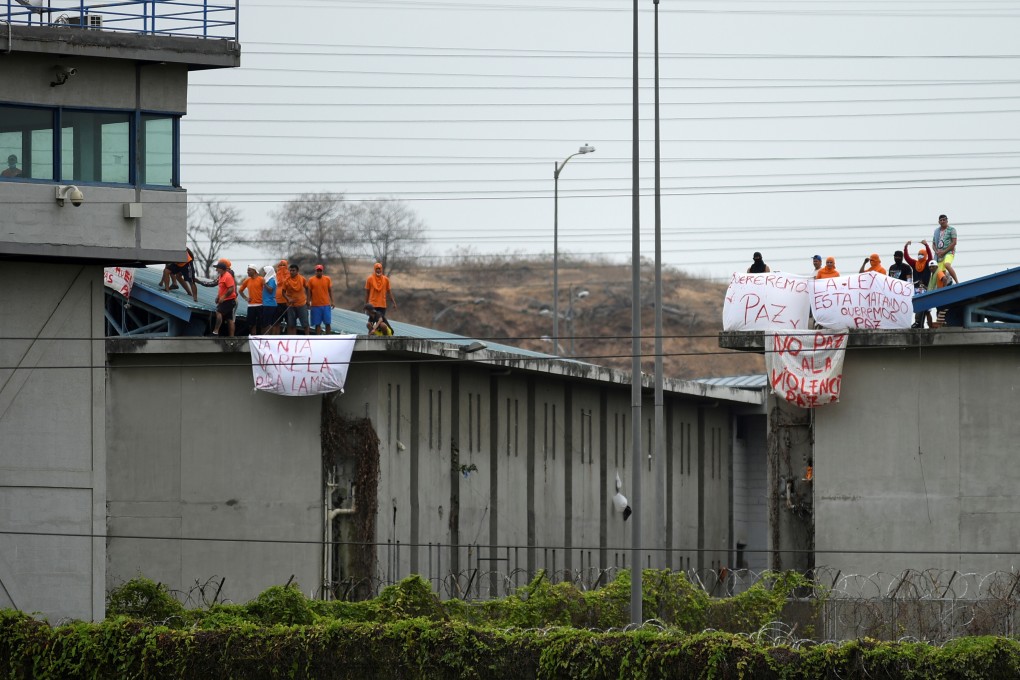 Inmates of the Regional de Guayaquil prison hold banners calling for peace after riots broke out at the Penitenciaria del Litoral, in Guayaquil, Ecuador on October 2. Photo: Reuters