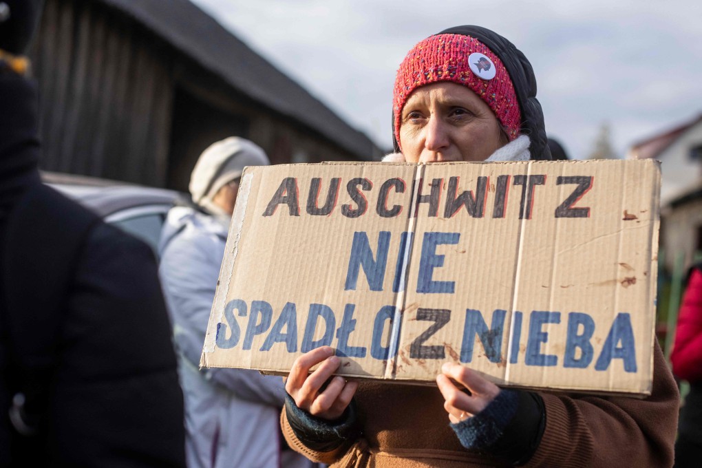 A woman holds a banner reading ‘Auschwitz did not come out of nowhere’ as she takes part in protest initiated by Polish mothers in Michalowo, Poland on Saturday. Photo: AFP