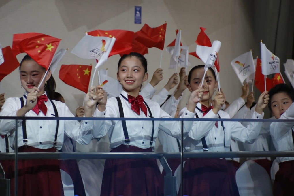 Children wave Chinese national flags at the welcome ceremony for the flame of the Beijing 2022 Winter Olympic Games. China now follows in Tokyo 2020’s footsteps for the second Games during the pandemic. Photo: EPA