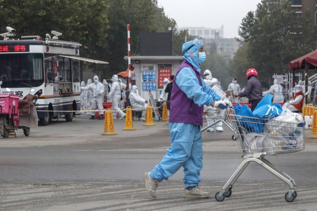 Staff in protective suits secure a residential neighbourhood and deliver necessities after new coronavirus cases were recorded in Beijing. Photo: EPA-EFE