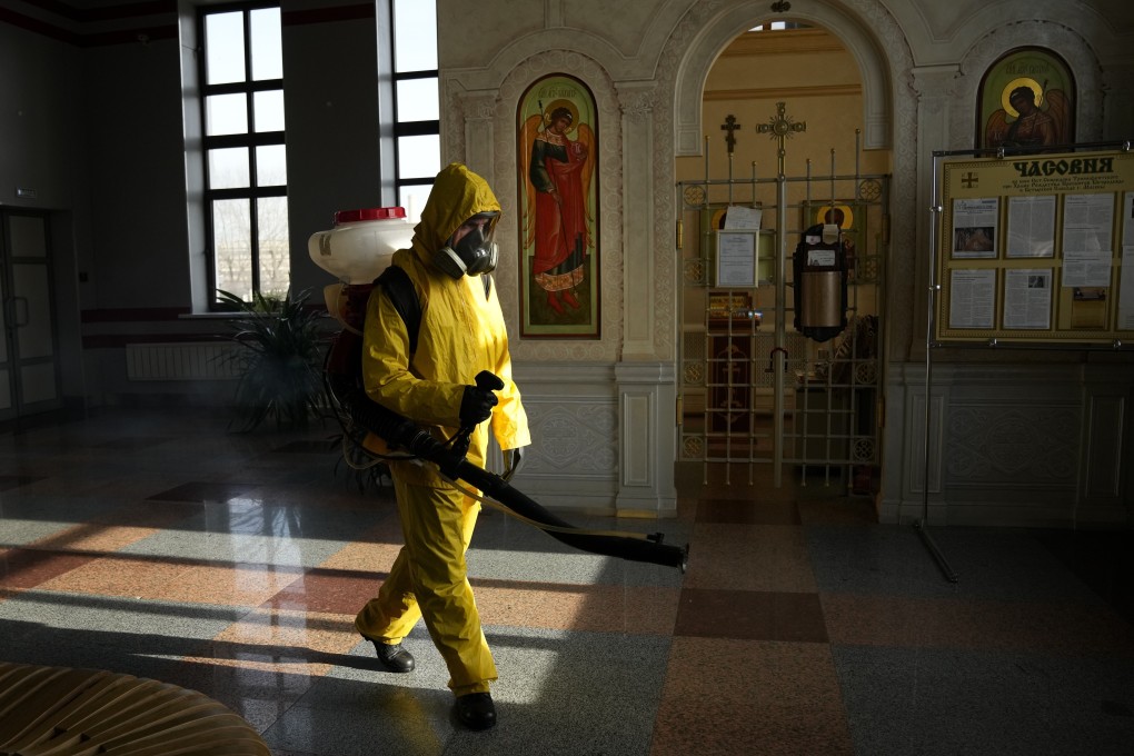 A Russian emergency worker disinfects an area inside Savyolovsky railway station in Moscow. Photo: AP