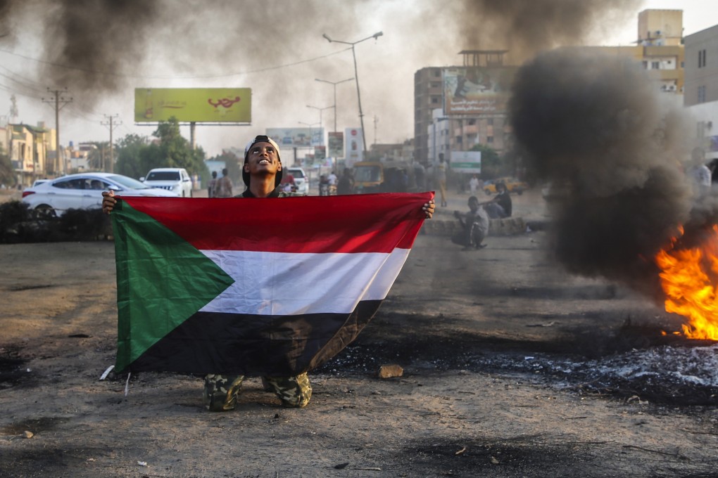 A Sudanese protester holds the national flag during a demonstration in the capital Khartoum on Tuesday. Photo: EPA-EFE