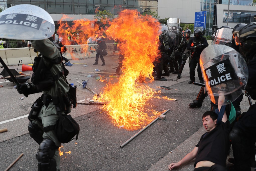A petrol bomb lands near riot police, close to Ngau Tau Kok Police Station, on August 24, 2019. Photo: Sam Tsang