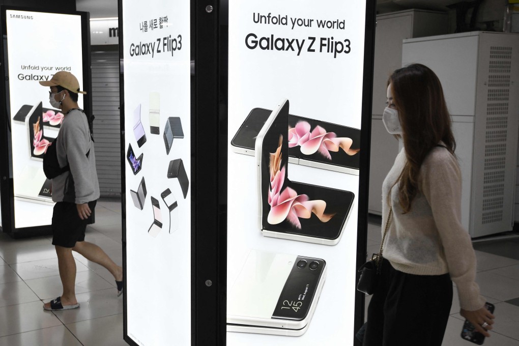 Pedestrians walk past an advertisement for Samsung Electronics’ Galaxy Z Fold3 and Flip3 smartphones at an underground shopping area in Seoul, South Korea, on October 8, 2021. Photo: Agence France-Presse