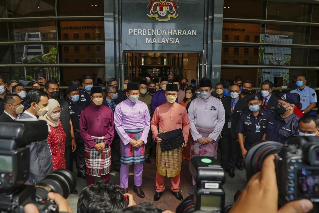 Malaysian Finance Minister Tengku Zafrul Abdul Aziz holds a briefcase containing the 2022 Budget as he leaves the Finance Ministry to head to Parliament House in Putrajaya. Photo: EPA