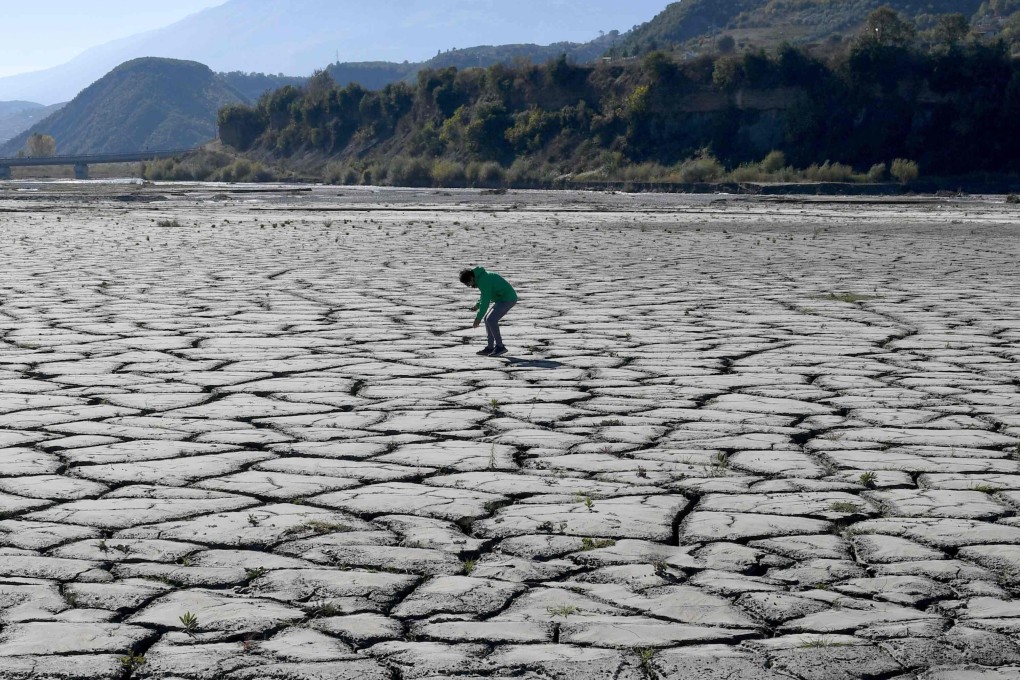 A man looks at the dried-up bottom of the Banja hydro-power plant reservoir near Gramsh, central Albania, on Friday. Albania has been stricken by an uneven pattern of rains this year. Photo: AFP