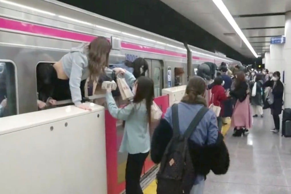 People escape through windows of a Tokyo train line following a knife, arson and acid attack in Tokyo. Photo: Twitter user @SIZ33 via Reuters
