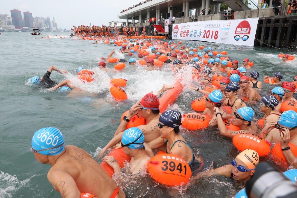 Swimmers swim across Victoria Harbour from Tsim Sha Tsui to Wan Chai Golden Bauhinia Square Public Pier during the 2018 New World Harbour Race, when it was last held. Photo: Robert Ng