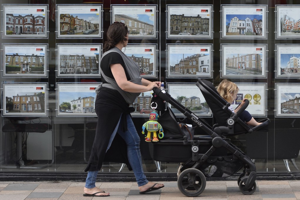 A woman looks at adverts in an estate agent window in south-west London. Photo: EPA-EFE
