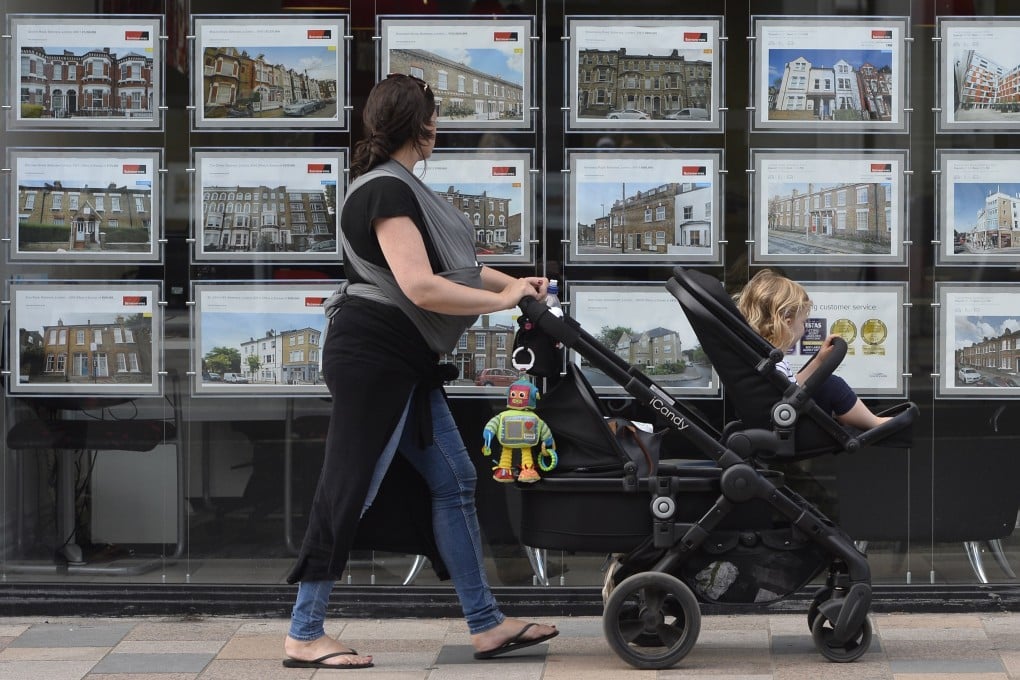 A woman looks at adverts in an estate agent window in south-west London. Photo: EPA-EFE