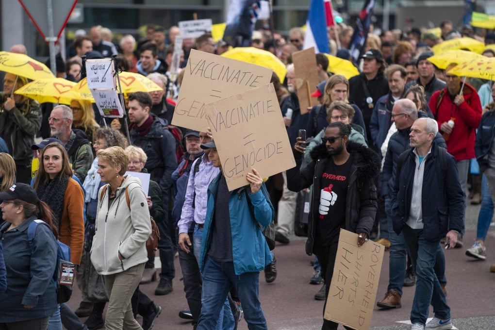 Protesters hold signs reading ‘vaccination is genocide’ during a rally against the Covid-19 health pass in Utrecht, the Netherlands in October. Photo: AFP