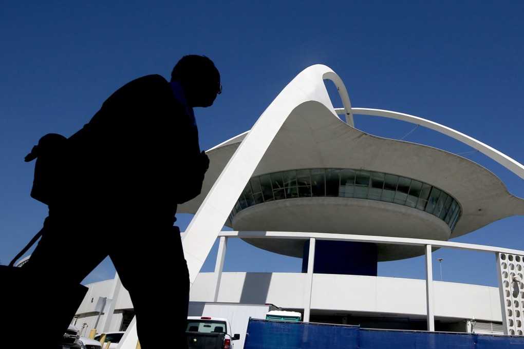 A pedestrian walks past the Theme Building between Terminals 2 and 6 at Los Angeles International Airport in 2017. Photo: TNS