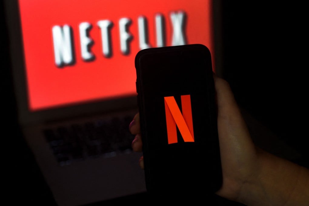 A computer screen and mobile phone display the Netflix logo on March 31, 2020. The streaming giant has launched its first video game service on Android with games based on its hit series Stranger Things. Photo: AFP