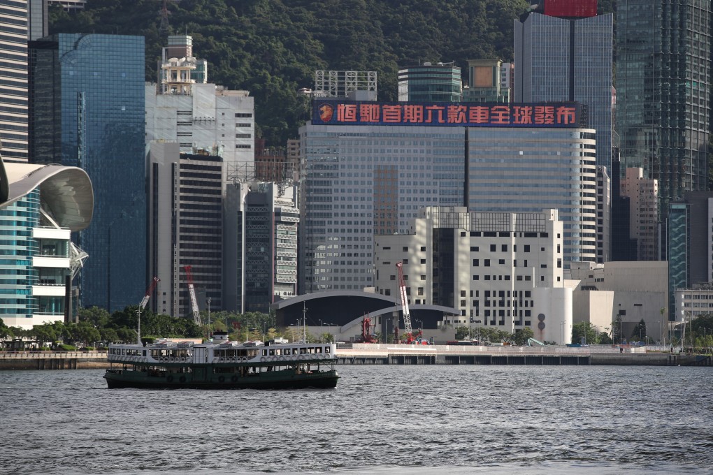 China Evergrande Group’s corporate headquarters office tower at the Wan Chai waterfront in Hong Kong, with a roof billboard announcing the launch of Evergrande’s electric cars on 1 September 2021. The carmaker has yet to deliver any vehicle to customers. Photo: Edmond So.