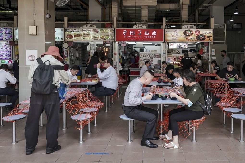 Patrons sit in pairs at cordoned off tables at the Amoy Street Food Centre, in Singapore, in June. Photo: EPA-EFE