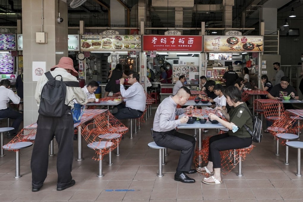 Patrons sit in pairs at cordoned off tables at the Amoy Street Food Centre, in Singapore, in June. Photo: EPA-EFE